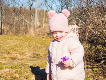 portrait of a little girl with flowers in a spring square
