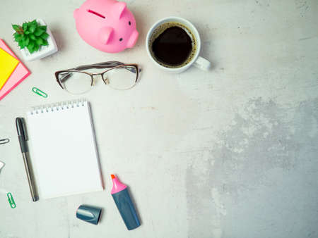 piggy bank on the table with notepad and glassesの写真素材