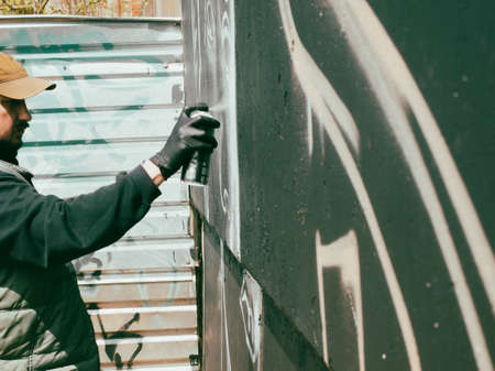 a guy in a cap draws graffiti, the concept of street urban artの写真素材