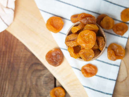 Dried dried apricots in a bowl on an old wooden table. dried fruitsの写真素材