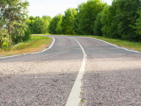 Empty turning rural highway under blue sky on a summer day