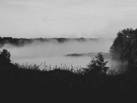 Sunrise over a foggy lake. early morning on the river. sunrise and mist over water and trees with reflections on the river bank.の写真素材