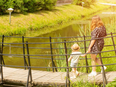 mother and little daughter walk in the park by the handの写真素材