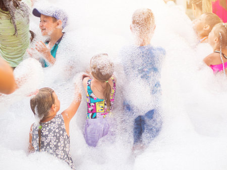 Moscow. russia. 08.06.2023 joyful children having fun at a foam partyの写真素材