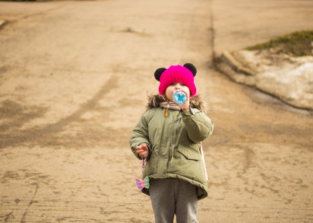 child drinks water from a bottle on the street