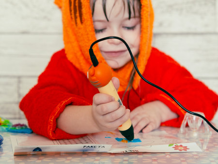 Children's hands make a craft using a 3D printing pen. A girl draws with a 3D pen.