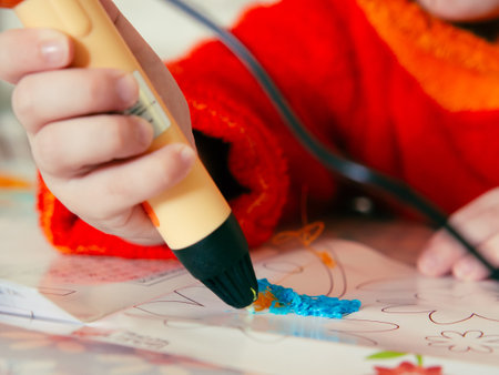 Children's hands make a craft using a 3D printing pen. A girl draws with a 3D pen.の写真素材