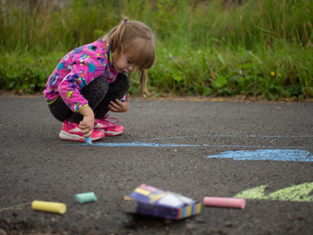 girl draws with colored chalk on the asphaltの写真素材