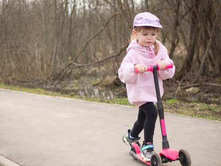 girl riding a scooter on a spring dayの写真素材