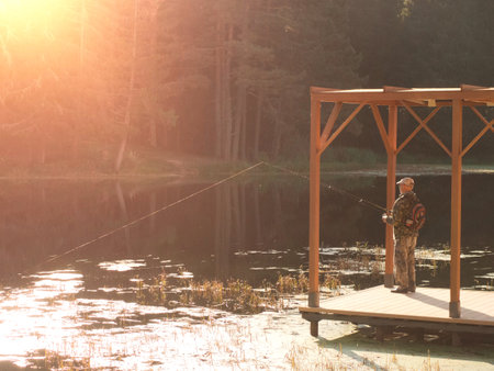 fisherman fishing with spinning rod from the pierの写真素材
