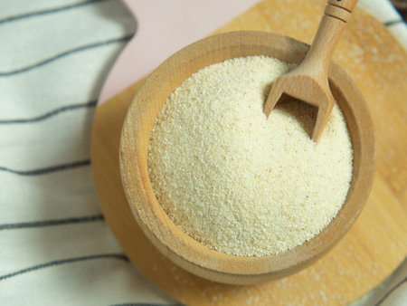 Organic semolina in a wooden bowl with a spoon on a wooden table.の写真素材