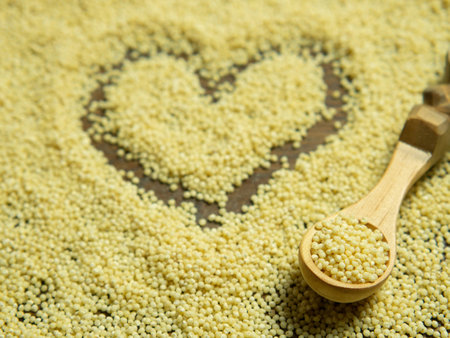 Heap of millet groats on wooden background with space for text. Raw organic healthy millet.の写真素材
