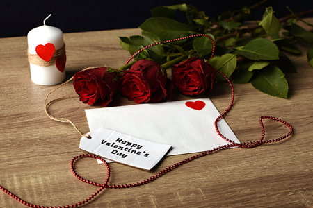 Red rose, white envelope and ribbons. Gift for loved ones