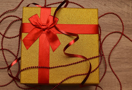 Gold gift with red ribbons. Gift for loved onesの写真素材