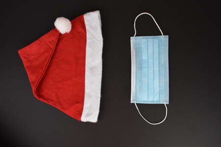 Red Christmas hat and mask on the dark
