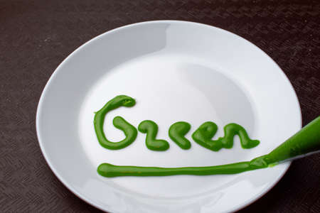 Written in green glaze on a white plate. Lettering - greenの写真素材