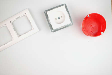 Electrician. White socket, socket cover and red socket box. Renovation concept. Copy space. Flat...