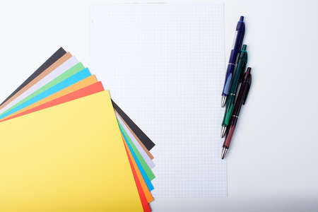Colored paper, checkered sheets and three pens. Isolateの写真素材