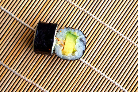 Rolls with avocado on a bamboo mat. Copy space. Flat lay