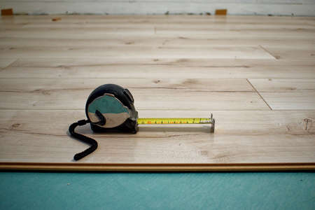 The tape measure lies on the laminate. The process of laying laminate flooring.の写真素材
