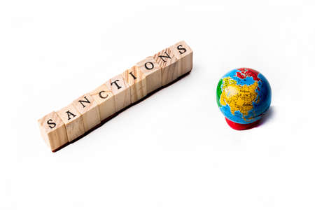 Isolate of wooden letters folded into the word sanctions and small globe nearby.の写真素材