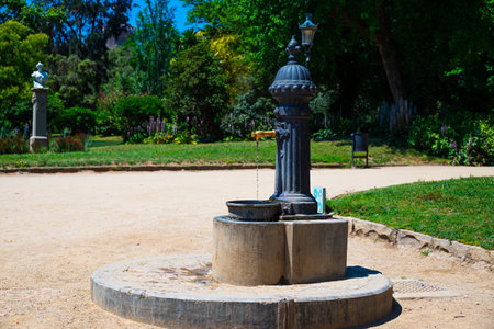 Spain, Barcelona - May 30 2022: Small, metal fountain-column with free drinking water in the Ciutadella Park.のeditorial素材