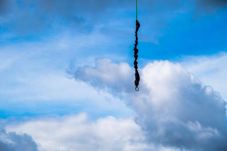 Against the background of a blue sky with clouds hangs a mount for rope jumping in Sloka, Jurmala, Latvia.の写真素材