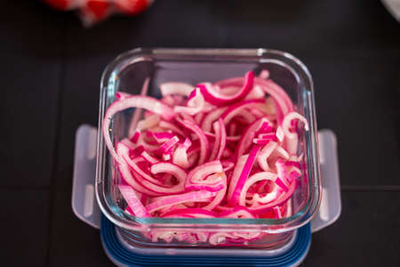Close-up of finely chopped, red and pickled onions in a glass bowl. food in nature. Small depth of field.の写真素材