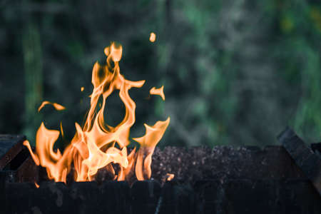 The fire from charcoal flares up in the grill. copyspace.の写真素材