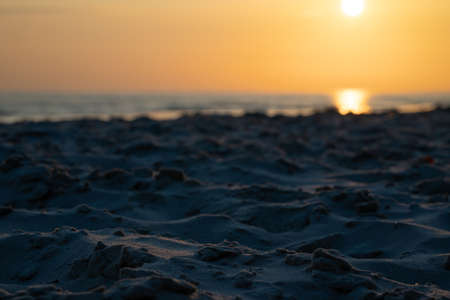 In The Foreground Is The Sand On The Beach, Against The Backdrop Of An Out-Of-Focus Sunrise In Jurmala, Latvia. Small Depth Of Field.の写真素材