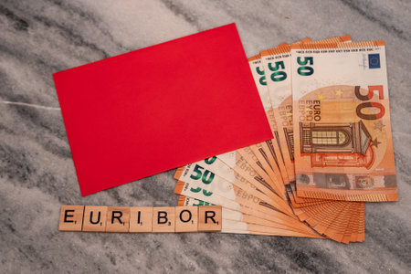 Word EURIBOR Is Written In Wooden Letters, Near Part Of 50 Euro Banknotes and Red Envelope.