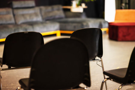 Black Plastic Chairs Are Arranged In Rows For Spectators Of Seminar At Exhibition. Blurred...