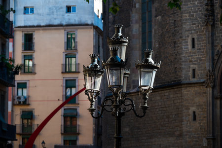 Barcelona, Spain - May 26 2022: An old beautiful street lamppost for lighting the streets of the Gothic quarter, against the backdrop of an old stone cathedral.のeditorial素材