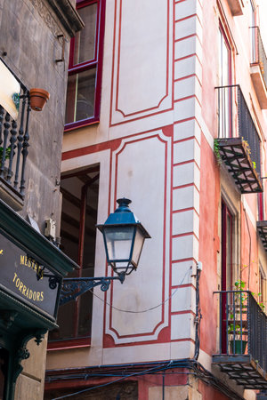Barcelona, Spain - May 26 2022: An old metal street lamp on a house building in a narrow street of the Gothic quarter.のeditorial素材