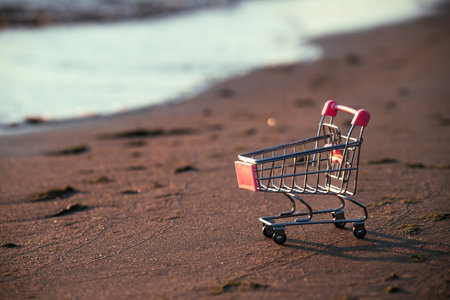 On Sand Is Miniature Shopping Cart, Concept Of Summer Sale. Like Hot Summer Sun, Summer Sales Give You Hot Discounts On Fashion Items.の写真素材