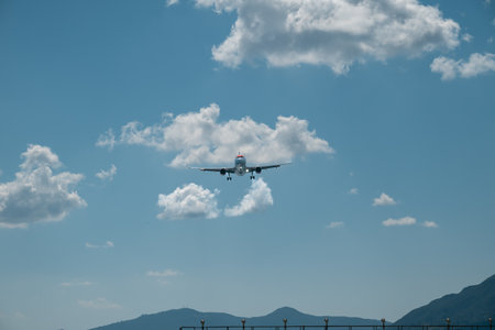 Kerkyra, Greece - 09 24 2022: Front view of Easy jet airplane flying Over mountains against a blue...