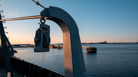 A metal pole with a chain hanging from it is above a body of waterの写真素材