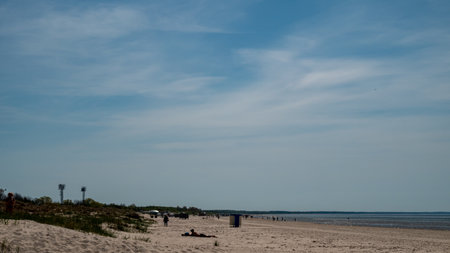 A beach with a few people and a blue skyの写真素材