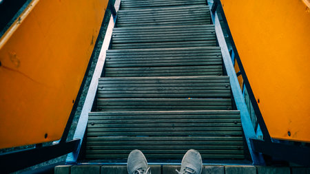A person is standing on a staircase with their feet on the steps