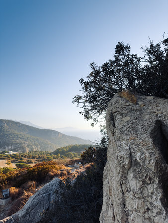 Breathtaking View of Rolling Hills and Rocky Outcrops Under a Clear Sky During the Golden Hour in a Serene Landscapeの写真素材