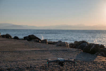 A drone is sitting on the beach near the water