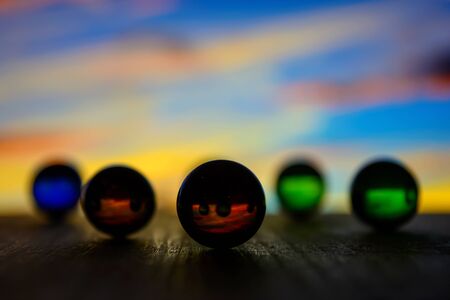 Photo of many color glass balls on wooden board on blurred backgroundの写真素材