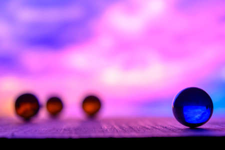 Photo of many color glass balls on wooden board on blurred backgroundの写真素材