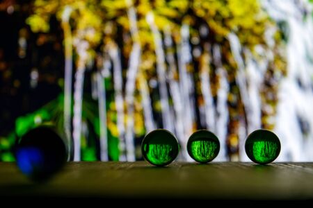 Photo of many color glass balls on wooden board on blurred backgroundの写真素材