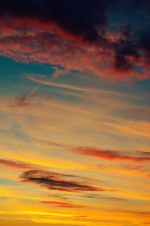 Photo of beautiful orange sunset with dark clouds on skyの写真素材