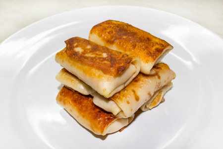 Traditional russian pancakes, wrapped in form with stuffing on the white plate. Homemade kitchen of Russiaの写真素材