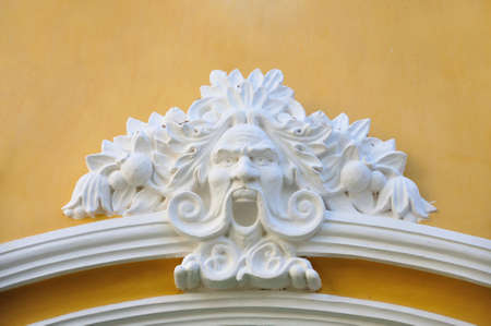 White sculpture of deva on yellow wallの写真素材