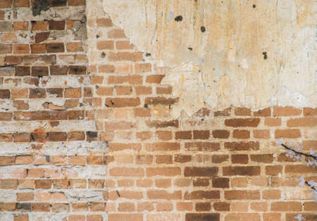 Red clay stained on the white exposed brick concrete wall の写真素材
