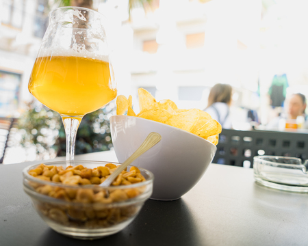Aperitif - beer and chips on an open air snack bar tableの写真素材