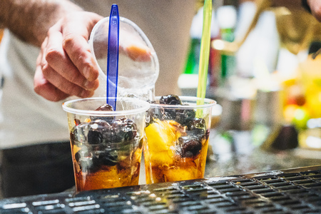 The bartender prepares a mixed fruit with soda water, fresh fruit and syrup in a typical kiosk in Catania.の写真素材